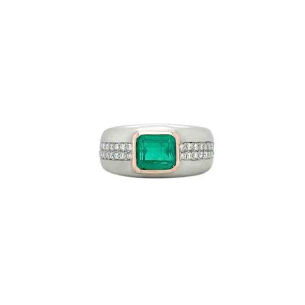 One white gold ring features a bezel set emerald gemstone with a tiny diamonds encrusted in a plated band . The ring rests in a white background.